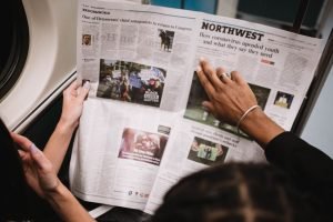 People reading a newspaper on a subway train, highlighting current events and diverse perspectives. — Importance of understan