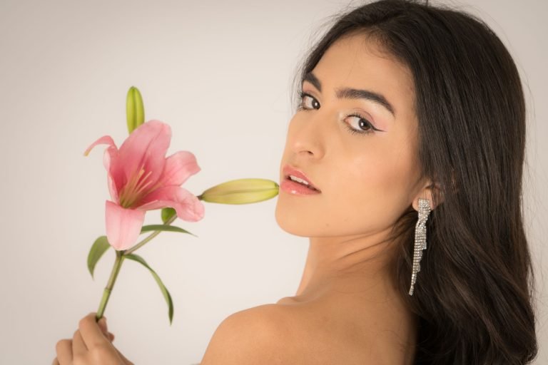 Elegant portrait of a woman with a pink lily, showcasing beauty and style. — What are the top 10 global issues in nutrition a